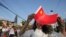 A woman holds a Chinese flag and stands by the side of a road to welcome Chinese President Xi Jinping in Kathmandu, Nepal, Oct. 12, 2019. 