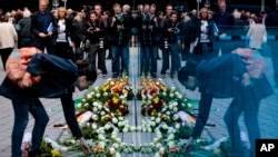 A woman lays flowers at the new monument for the victims of euthanasia in Berlin, Sept. 2, 2014.