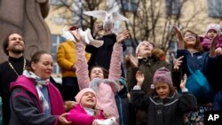 Children and their parents release birds celebrating the Annunciation on the eve of Orthodox Easter in front of the St. Tatiana Church in Moscow, Russia.