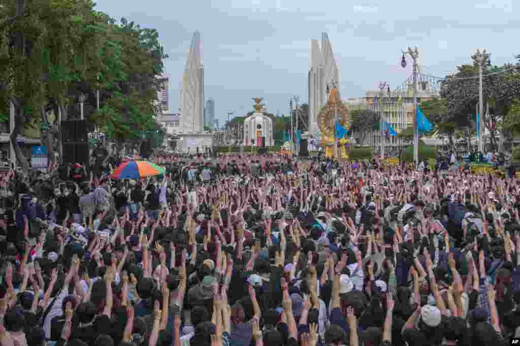 Pro-democracy students raise three-fingers, symbol of resistance salute, during a rally in Bangkok, Thailand.
