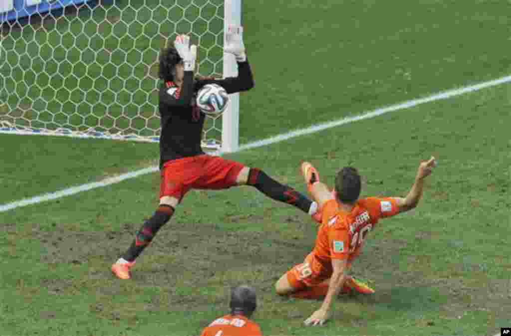 Mexico's goalkeeper Guillermo Ochoa makes a save after a shot by Netherlands' Klaas-Jan Huntelaar during the World Cup round of 16 soccer match between the Netherlands and Mexico at the Arena Castelao in Fortaleza, Brazil, Sunday, June 29, 2014. (AP Photo