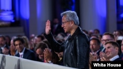 资料照片：英伟达首席执行官黄仁勋(Jensen Huang)在华盛顿特区安德鲁·W·梅隆礼堂举行的白宫人工智能峰会上受到特朗普总统的表彰。(2025年7月23日)