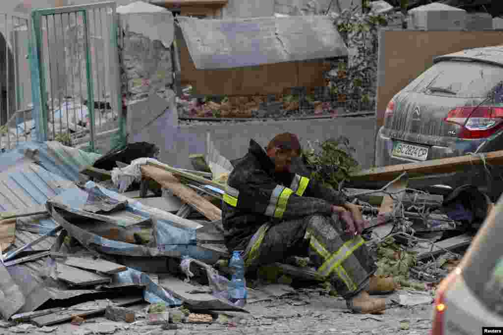 A rescuer rests at the site of a Russian drone and missile strike on residential buildings in Lviv, Ukraine. REUTERS/Roman Baluk