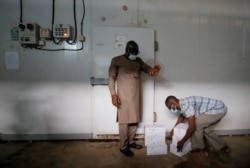 Seorang pekerja menyimpan kotak vaksin di ruangan dingin saat negara tersebut menerima batch pertama vaksin COVID-19 di bawah skema COVAX, di Accra, Ghana, 24 Februari 2021. (REUTERS / Francis Kokoroko)