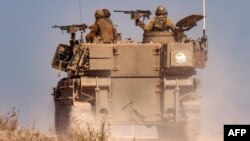 An Israeli army artillery howitzer moves at a position near the border with the Gaza Strip in southern Israel on November 3, 2023 amid the ongoing battles against Hamas militants. 