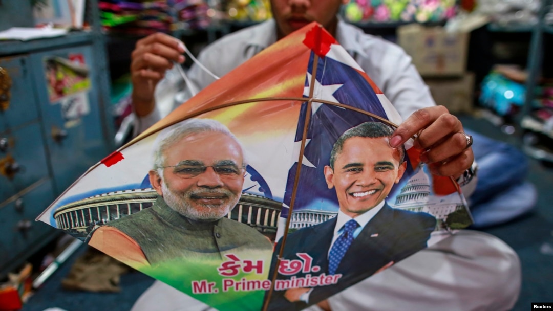 Seorang pekerja di Mumbai, tengah menjahit layang-layang bergambar PM India Narendra Modi (kiri) dan Presiden AS Barack Obama, menyambut kedatangan Presiden Obama ke negara tersebut (23/1).