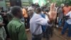 FILE - Evans Mawarire waves goodbye as he is taken into a prison truck at the magistrates courts in Harare.
