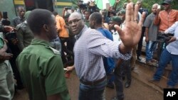 Evans Mawarire salue la foule avant de monter dans un camion prison truck at the magistrates courts in Harare.