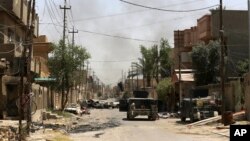 Kendaraan militer Irak melakukan patroli di kota Fallujah, yang berhasil dibebaskan sepenuhnya dari militan ISIS (27/6). 