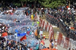 Los manifestantes se cubren con nylon por si la policía en Yangon, Birmania, usa cañones de agua para apaciguar las protestas.