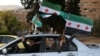 People celebrate with the Syrian opposition flag, in Damascus, Dec. 10, 2024. 