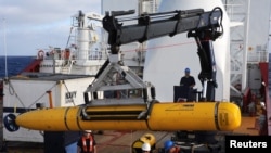 Crew aboard the Australian Defence Vessel Ocean Shield move the U.S. Navy's Bluefin-21 autonomous underwater vehicle into position for deployment in the southern Indian Ocean to look for the missing Malaysia Airlines flight MH370, April 14, 2014.