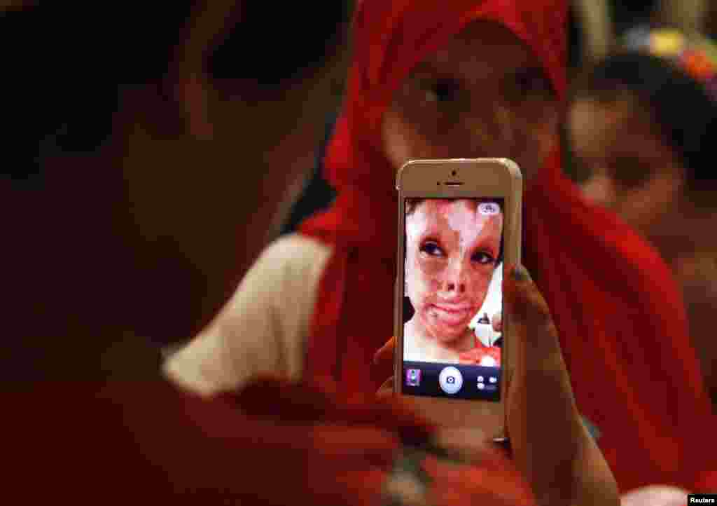 A child takes a picture with a mobile phone at an Eid al-Fitr party for Syrian and Iraqi refugee children injured during violence in their countries organized by the French humanitarian aid organisation Medecins Sans Frontieres (Doctors Without Borders) in Amman, Jordan.