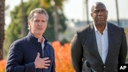 El gobernador de California, Gavin Newsom, izq, anunció la nueva iniciativa privada LA Rises, copresidida por la leyenda del baloncesto Earvin "Magic" Johnson, para apoyar la reconstrucción tras los devastadores incendios forestales en Los Ángeles, el 28 de enero de 2025.