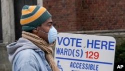 Voters observe social distancing guidelines as they wait in line to cast ballots while ignoring a stay-at-home order over the coronavirus threat to vote in Wisconsin’s presidential primary election, April 7, 2020, in Milwaukee.