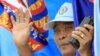 Supporters of the ruling Cambodian People's Party wave from a vehicle during a commune elections campaign rally in Phnom Penh, Friday, May 18, 2012.