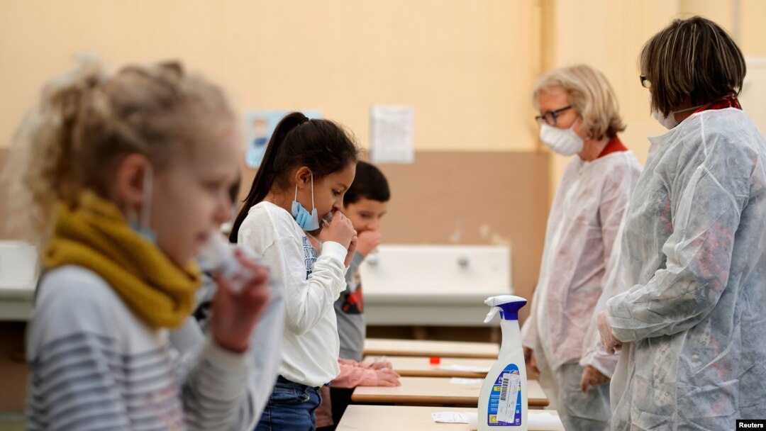 FILE - School children attend a COVID-19 saliva test in a primary school in Nice, as part of the coronavirus disease (COVID-19) testing campaign in France, March 8, 2021. 