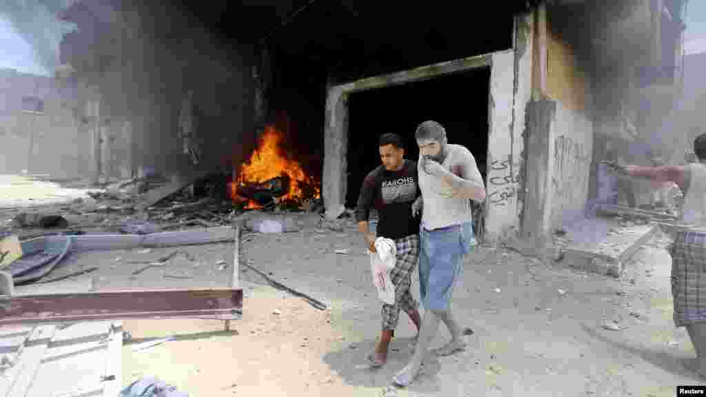 Un Palestinien évacue un blessé suite à une frappe aérienne israéliennem selon la police, sur une maison à Rafah dans le sud de la bande de Gaza, 20 Juillet 2014.