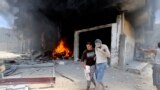A Palestinian evacuates a wounded man following what police said was an Israeli air strike on a house in Rafah in the southern Gaza Strip. At least 50 Palestinians were killed by Israeli shelling in a Gaza neighborhood, where bodies were strewn in the street and thousands fled for shelter to a hospital packed with wounded, witnesses and health officials said.
