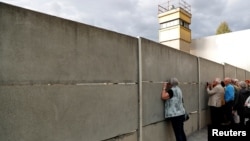 Para turis mengunjungi memorial Tembok Berlin di Bernauer Strasse, Berlin, Jerman menjelang peringatan 30 tahun runtuhnya Tembok Berlin. 