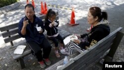 FILE - Ol Nishimura, a 51-year-old former Cambodian refugee, has lunch with his family during Asia Sports Festa in Yokohama, south of Tokyo, Japan, Oct. 25, 2015. 