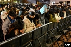 People pay tribute to the victims of the Jeju Air plane crash during a countdown event to mark the 2025 New Year, at the Bosingak pavilion in central Seoul before midnight on Dec. 31, 2024.