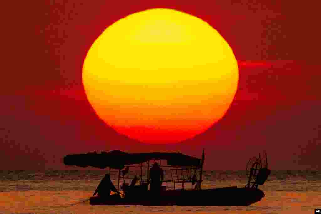 The sun sets as a a fishing boat crosses the Mediterranean Sea at Ramlet al-Baida beach in Beirut, Lebanon, April 18, 2020.