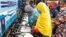 Les gens utilisent une station de lavage des mains installée pour les membres du public entrant sur un marché à Dodoma, en Tanzanie, le 18 mai 2020.