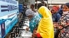 FILE - People use a handwashing station installed for members of the public entering a market in Dodoma, Tanzania, May 18, 2020. Tanzania’s government stopped reporting cases of COVID-19 in May. 