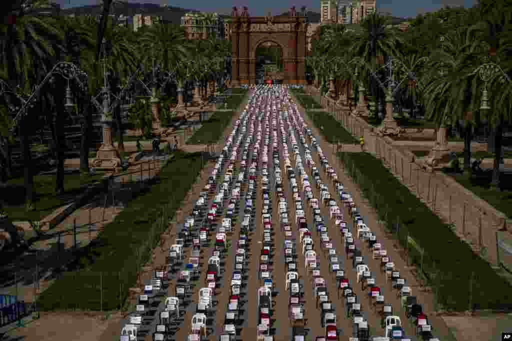 Empty chairs with the names of activists are seen placed on a street with the triumphal arch at the background, during a symbolic event marking Catalan National Day in Barcelona, Spain.