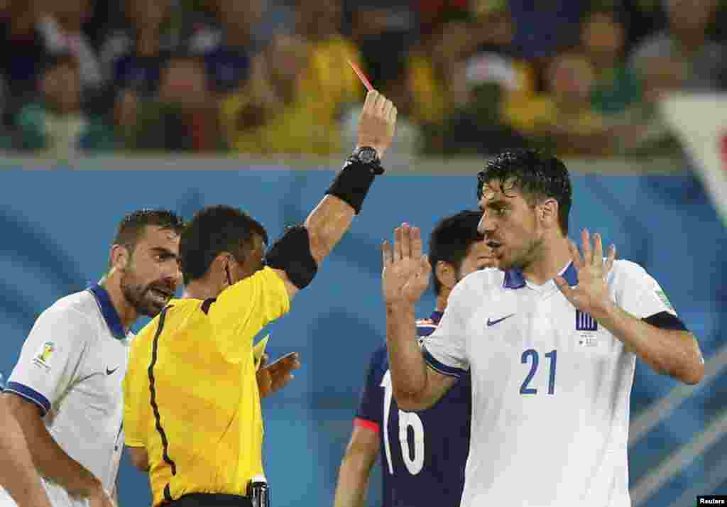 Greece's Kostas Katsouranis is shown a red card by referee Joel Aguilar of El Salvador during their 2014 World Cup Group C soccer match against Japan at the Dunas arena in Natal, June 19, 2014.