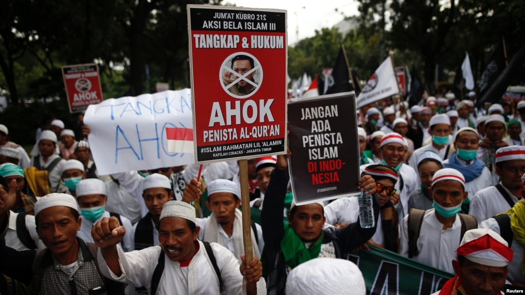 Demonstran membawa papan bertuliskan tuntutan atas penangkapan Gubernur Jakarta Basuki "Ahok" Tjahaja Purnama, yang dianggap menistakan agama, di Jakarta (2/12). (Reuters/Darren Whiteside)