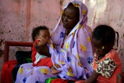 Members of a family beneficiary of a cash support system are pictured in Khartoum on July 9, 2020. Sudan is distributing cash handouts under an internationally backed plan to help millions cope with an economic crisis aggravated by COVID-19.