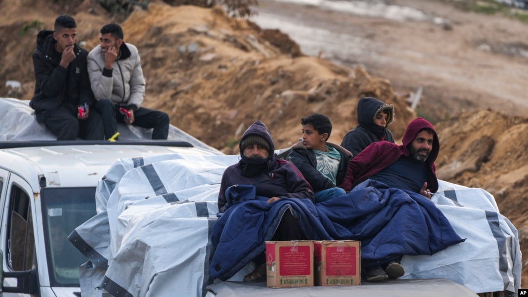 Warga Palestina duduk di atas kendaraan saat menunggu di pos pemeriksaaan di koridor Netzarim dalam perjalanan mereka menuju utara Jalur Gaza, pada 11 Februari 2025. (Foto: AP/Abdel Kareem Hana)