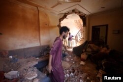 A man looks at the damage inside a house during clashes between the paramilitary Rapid Support Forces and the army in Khartoum, Sudan, April 17, 2023.