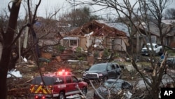 An emergency vehicle drives through a neighborhood in Rowlett, Texas, Sunday, Dec. 27, 2015.