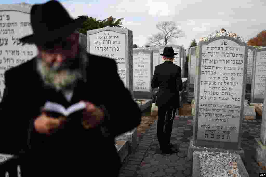 Chabad-Lubavitch rabbis gather in prayer at the resting place of the Rebbe Menachem M. Schneerson in the Old Montefiore Cemetery in the Queens borough of New York.