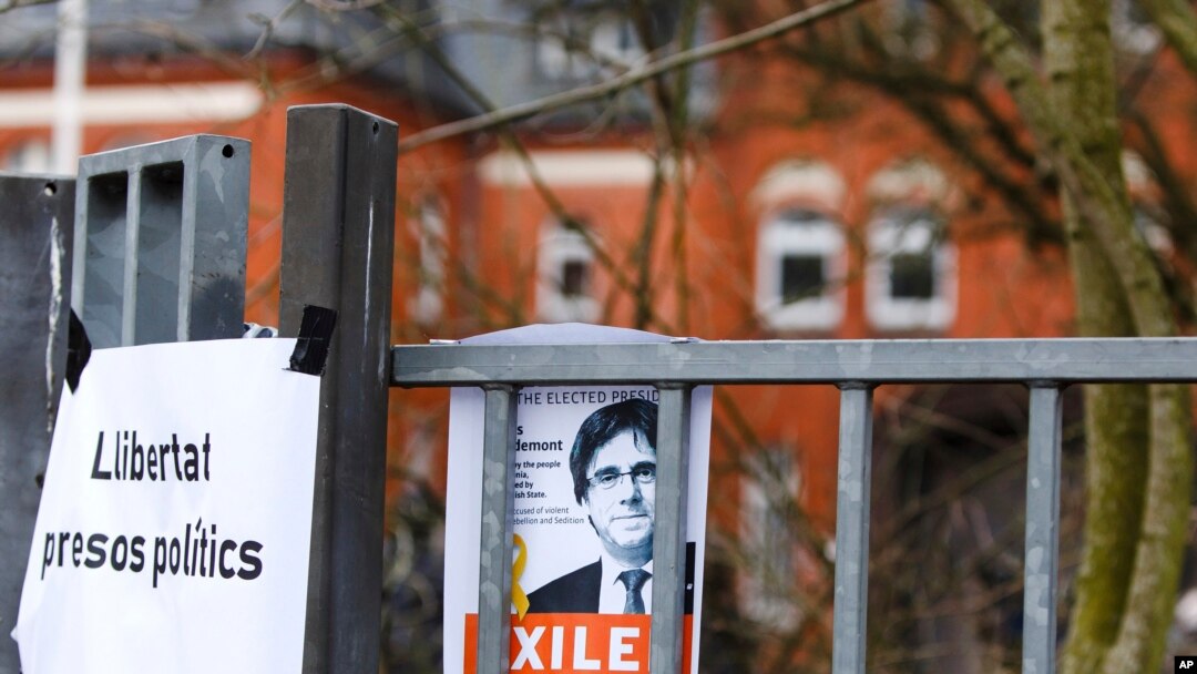 Gambar Carles Puidgemont ditempel di gerbang masuk penjara di Neumuenster, utara Jerman, Selasa, 27 Maret 2018. Carles Puigdemont, mantan pemimpin Catalonia yang sedang dalam pelarian, diyakini ditahan di penjara ini. Puidgemont ditangkap polisi Jerman saat berusaha memasuki negara ini dari Denmark. (Frank Molter/dpa via AP)