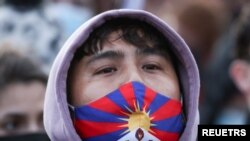 Foto ilustrasi yang menunjukkan seorang demonstran mengenakan masker dengan desain bendera Tibet dalam aksi protes di Konferensi Iklim PBB COP26 di Glasgow, Skotlandia, pada 6 November 2021. (Foto: Reuters/Yves Herman)