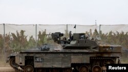 FILE — An Israeli armoured personnel carrier (APC) maneuvers near the Israel-Gaza border, amid the ongoing conflict between Israel and the Palestinian Islamist group Hamas, as seen from Israel, February 23, 2024.