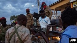 FILE - A young man is arrested by police during a curfew in Juba, South Sudan, April 9, 2020.
