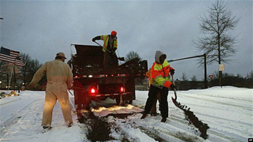 City contractors spread sand and tar on roadways in the early morning hours after an overnight winter storm that so far had deposited seven inches of snow in Johns Creek, Ga., Jan 10, 2011