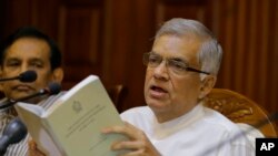 Perdana Menteri Sri Lanka yang tersingkir, Ranil Wickremesinghe memegang salinan konstitusi Sri Lanka saat menghadiri pengarahan untuk media di kediaman resminya di Kolombo, Sri Lanka, 29 Oktober 2018. (Foto: dok).