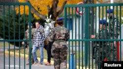 A French soldier arrives with flowers at the 5th Combat Helicopter Regiment (5th RHC) base in Uzein near Pau, France, Nov. 26, 2019. Thirteen French soldiers were killed in Mali when their helicopters collided at low altitude.