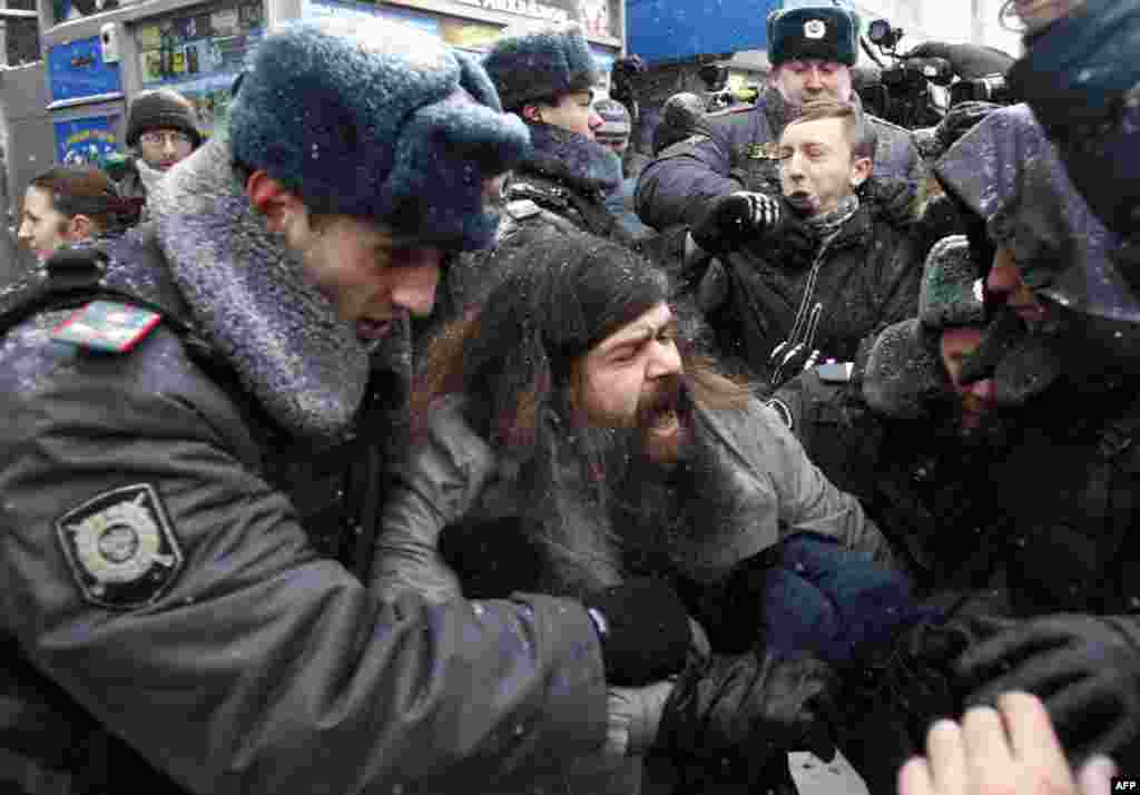 Policemen detain activists from the "Other Russia" opposition movement during a rally to protest against the first session of Russia's State Duma and violations held at the recent parliamentary elections in Moscow December 21, 2011. The State Duma, the lo