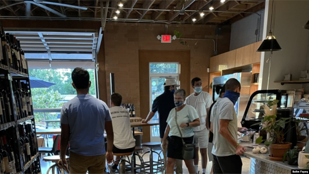 Patrons at a coffee shop in the trendy NoDa neighborhood of Charlotte, NC, wear masks. (Salim Fayeq/VOA)