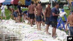 Thai soldiers pile up sand bags to make flooding barriers in Pathum Thani province, central Thailand Friday, Oct. 14, 2011.