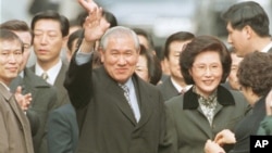 FILE - Former South Korean President Roh Tae-woo, with his wife, Kim Ok-sook, standing beside him, waves to supporters and neighbors after he was released from the Seoul prison in a special amnesty, Dec. 22, 1997.