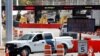 FILE - A U.S. Customs and Border Protection vehicle stands beside a sign reading that the border is closed to nonessential traffic, at the Canada-United States border crossing at the Thousand Islands Bridge, in Lansdowne, Ontario, Sept. 28, 2020. 