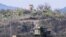 FILE - A file picture taken on April 15, 2022, from the South Korean border city of Paju shows soldiers, top outside a guard post in North Korea, as seen beyond a South Korean guard post, bottom.
